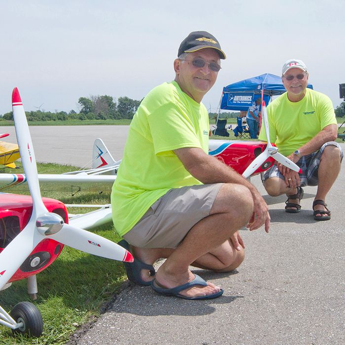 Karl Gross, left, and Dave Cummings, right, kneel in front of each of their Piper Pawnee model planes, which flew during the Chatham Warbirds and Classics show at the Chatham-Kent Municipal Airport on Saturday, July 20, 2013.