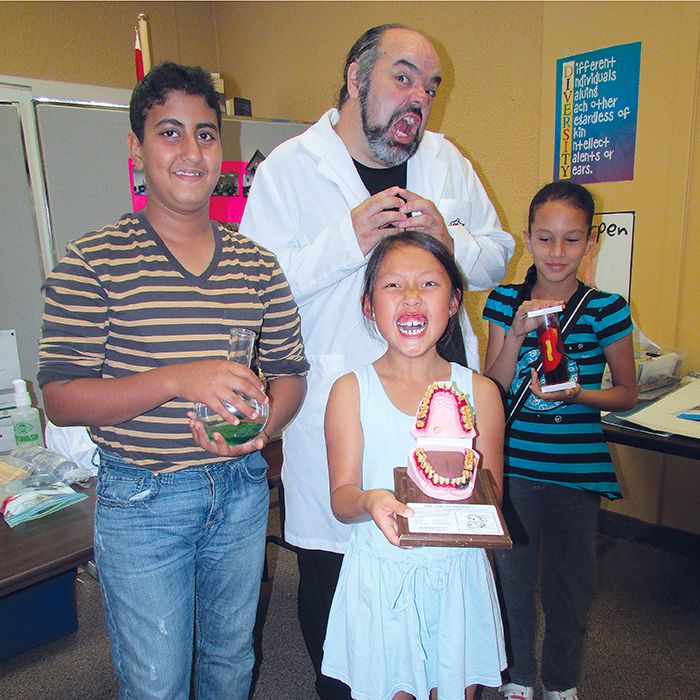 From left, Ali Baama, 12, Dorothy Li, 8 and Katerine Garcia, 8, hang out with Rob Tymec from Mad Science.