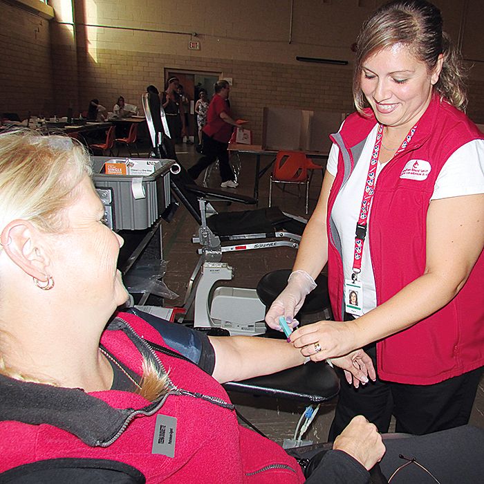 Canadian Blood Services staffer Angela O'Brien  prepares Teena Duquette before taking a pint of her blood at Wednesday's blood donor clinic at St. Joseph's Hall in Chatham. It was Duquette's 24th time giving blood.