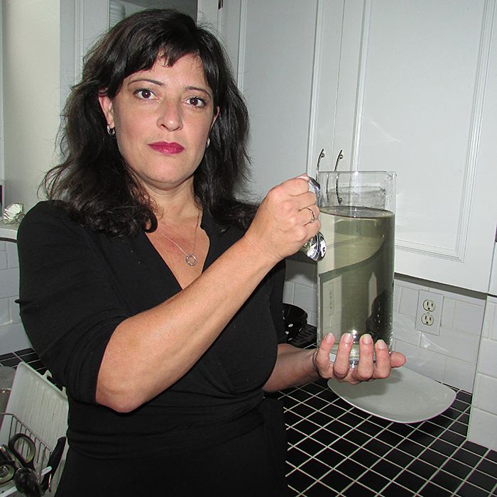 Chatham resident Penelope Duchesne shows off the water that came out of her tap this morning. She says it stinks and has no plans on drinking it.
