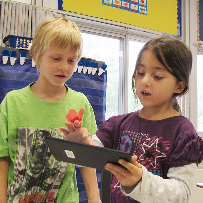 Grade 2 students Ashton Lovell, 7, and Hailey Dodge, 6, use an iPad mini for a math lesson at Victor Lauriston Public School. Rob Myers of RM Auctions donated $20,000 each to Lauriston and St. Joseph Catholic School to buy iPad minis for the classrooms.