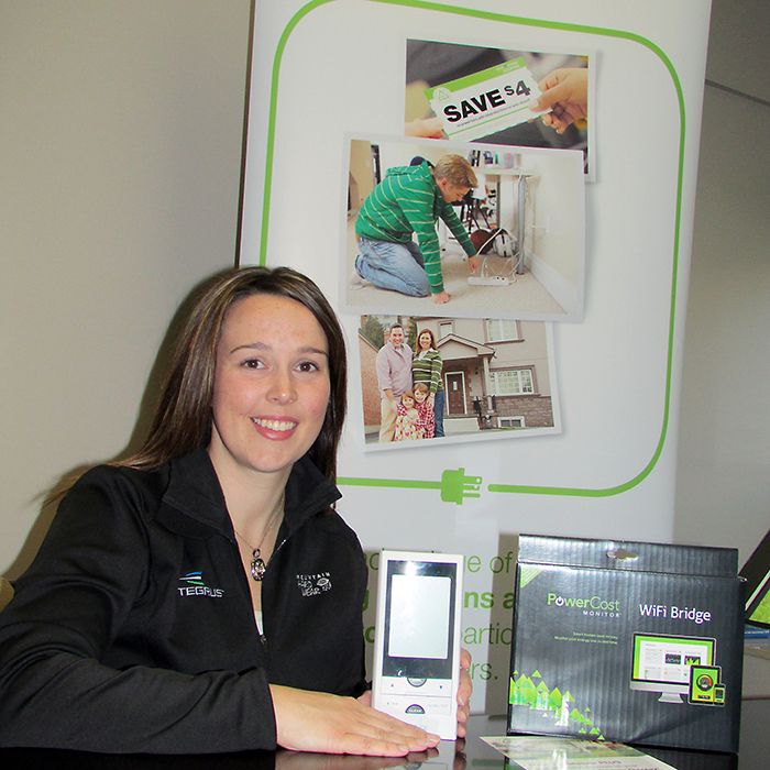 Entegrus’ Erin Bourdeau shows off the Peaksaver display unit that customers can sign up to have installed in their homes and small businesses as part of the Peaksaver Plus program. The display allows people to see their real-time energy consumption, in kilowatts and dollars and cents.