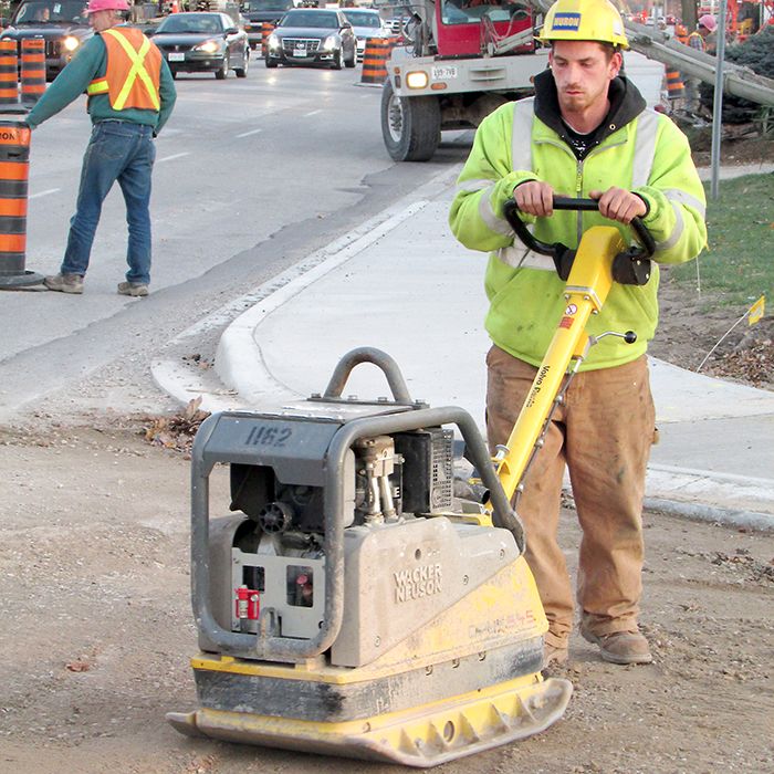 Huron Construction’s Jared Chabot tamps down the gravel at the intersection of Brook and St. Clair streets in Chatham recently.