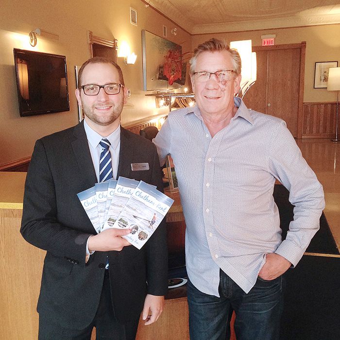 George East, left, of Retro Suites, is an advertiser in the Chatham-Kent Travel Guide. Here he receives one of the first copies from HUB Creative Group partner Ike Erickson.