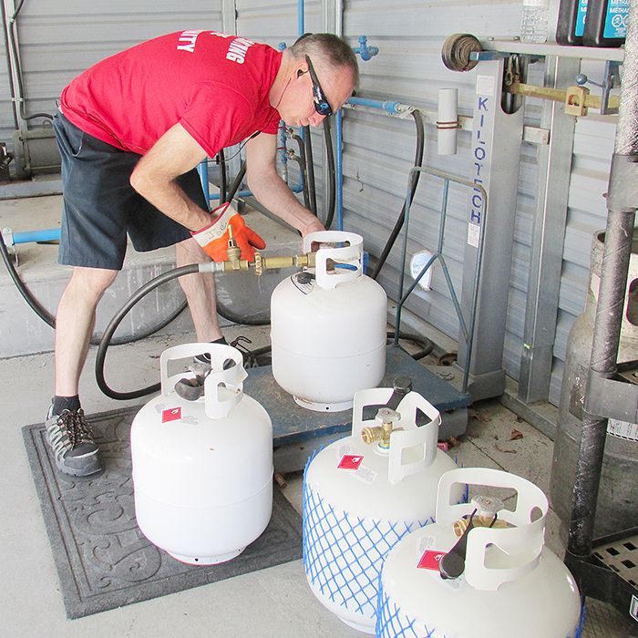 Dave Desjardins fills a propane tank, and has others lined up waiting for a refill at Dowler-Karn north of Chatham Saturday. The business is hosting a family fun day.