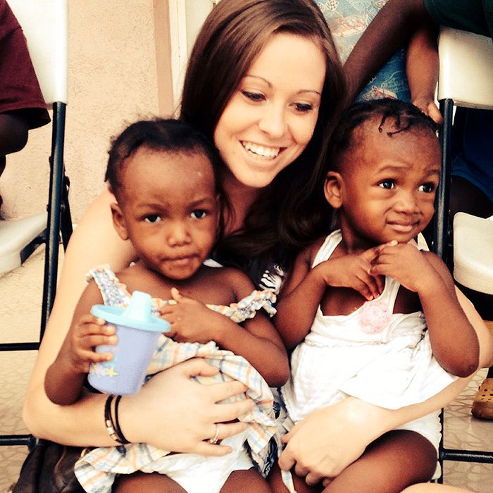 Emily Hime cuddles with two of the kids that live at the children's home she operates in Haiti.