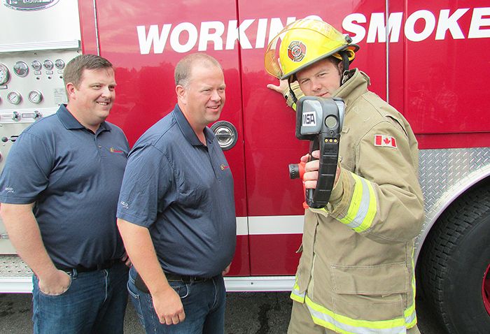 Chatham-Kent Firefighter James Labombard shows Enbridge Green Energy staffers, from left, John Bridges, site supervisor for the Talbot Wind Farm, and Ian MacRobbie, general manager, how a thermal imaging camera can detect heat sources. Enbridge donated $13,500 to pay for two of the cameras for the fire department.