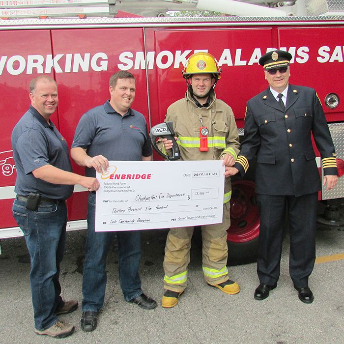 From left, Enbridge Green Energy’s Ian MacRobbie, general manager, and John Bridges, site supervisor for the Talbot Wind Farm, hand over a cheque for $13,500 to fund two thermal imaging cameras for the Chatham-Kent Fire Department to firefighter James Labombard and Bob Davidson, assistant fire chief.