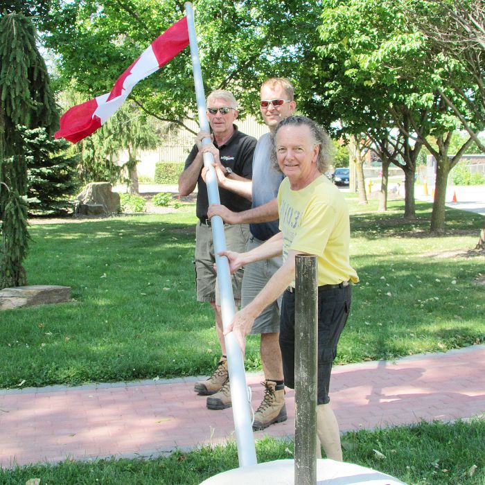 From left, Bill Ross and, yes, Bill Ross of Ross’ Nurserymen get a little help from Robert Laidlaw Ondrovcik in putting up a new flagpole at Veterans’ Tribute Garden on Thames Street in Chatham Aug. 28. The new pole is part of the second phase of revitalization taking place at the waterside park.