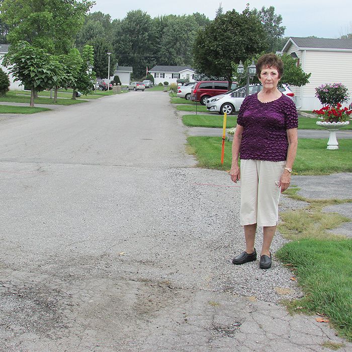 Elaine Meloche stands next to a section of crumbling pavement in St. Clair Estates. The  Ontario Landlord and Tenant Board has scheduled a hearing into the matter.