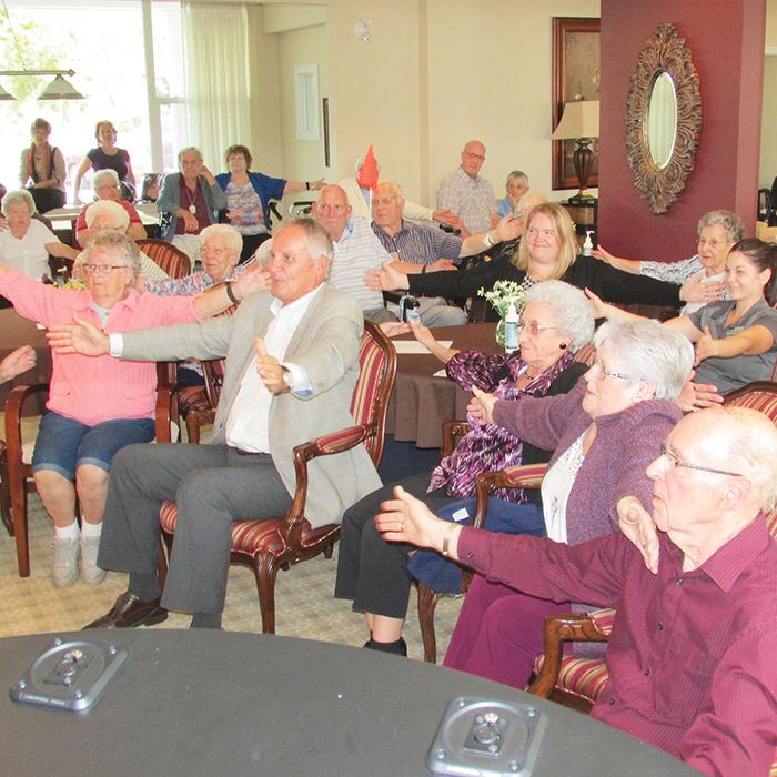 Gary Switzer, centre, CEO of the Erie St. Clair Local Health and Integration Network, leads a group of seniors in exercise at a recent announcement of increased funding for seniors’ exercise programs in the area.