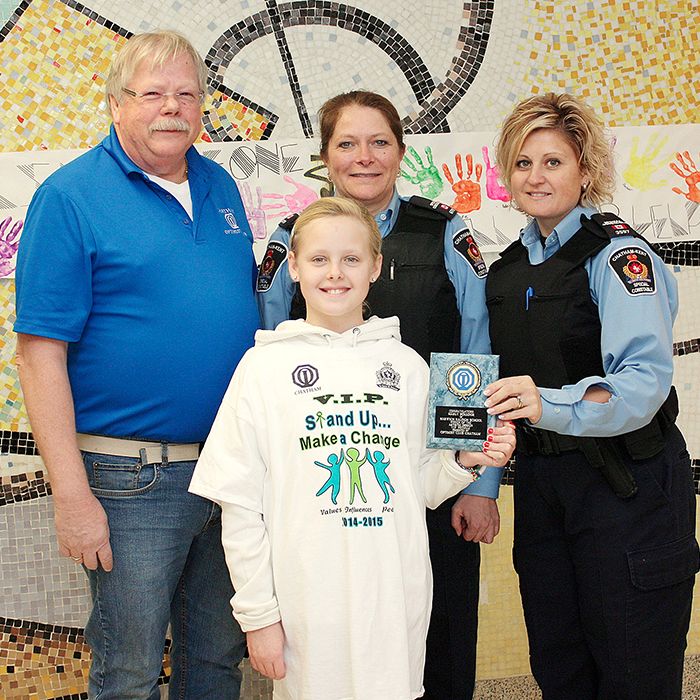 Back row, from left Chatham Optimist member Stevan Tuinstra and CKPS Spec. Consts. Brenda Koldyk and Randi Hull present Marly Pollock, front, with her award for providing the winning design in the VIP T-shirt contest.