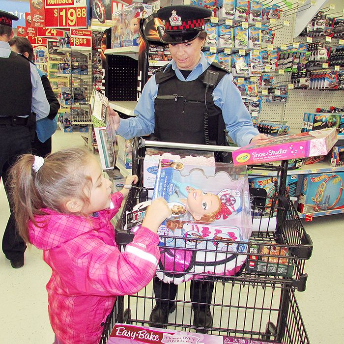 Aux. Const. Louise Martens helps Brooklyn Maracle, 6, with her Christmas shopping Saturday at Wal-Mart as part of the Shop with a Cop event. OPP and Chatham-Kent police officers and auxiliary volunteered to take 32 kids shopping Saturday morning.