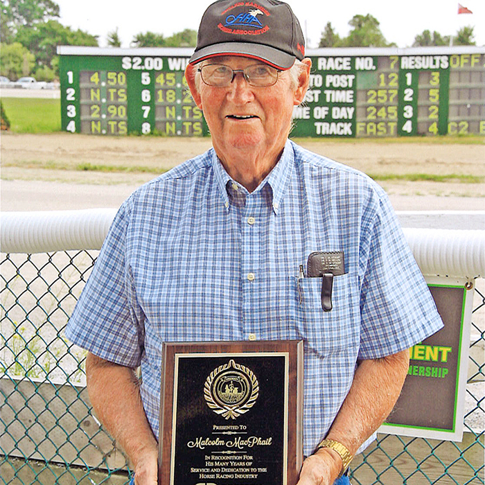 Malcolm MacPhail shows off his plaque honouring him as the first inductee into the Dresden Agricultural Society’s hall of fame for the Dresden Raceway this year. (Photo courtesy Dave Dufour)