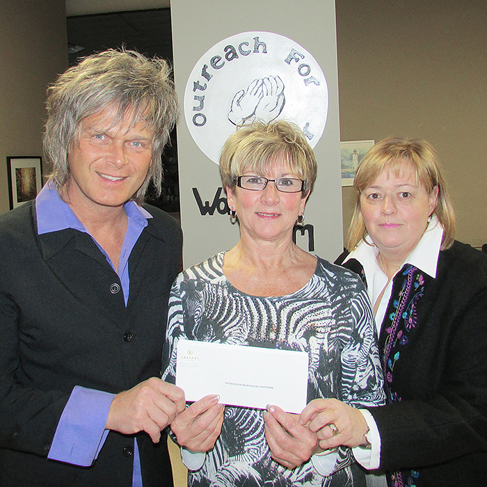 St. Clair College representatives Jeff Burrows, left, and Lynn McGeachy Schultz, right, donate $15,000 to Brenda LeClair of Chatham Outreach for Hunger Thursday.