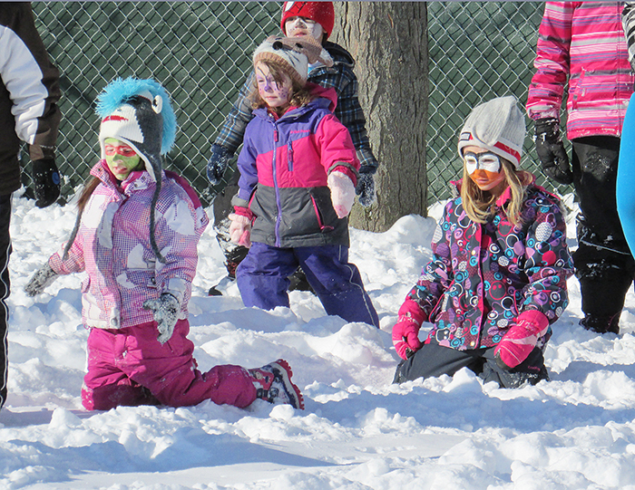 From left, Lilah Delatorres, Leah Pritchard and Cambrie Leatherdale play in the snow Thursday as part of St. Joe’s school winter carnival fun.