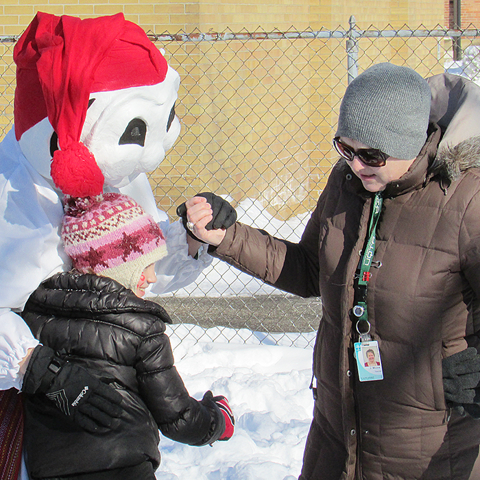 Teacher Jennifer Moore, right, introduces a special friend, Bonhomme, to students Thursday at St. Joe’s school, which embraced winter with carnival activities.