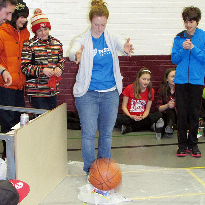 Ellen Sinclair drops a basketball on an egg capsule at the Professional Engineers of Ontario impromptu design challenge at John McGregor Secondary School Saturday.