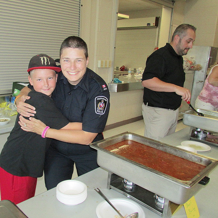 Const. Amy Finn, right, gets a big hug from Joey Reid, 11, at the annual community luncheon Friday. Members of the local police association, as well as East Side Pride put on the event.