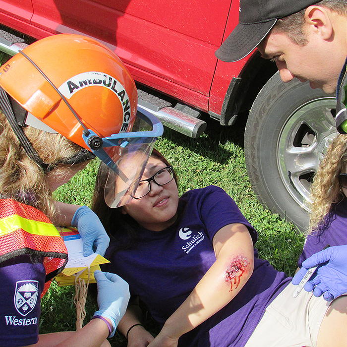 Student Sonja DeBruyn, left, comforts mock crash victim Nora Sonu under the guidance of paramedic Jon Benoit as part of the mock accident Friday in Percy Park in Chatham.