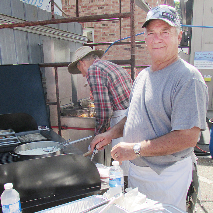 Dave Dodman with the Blenheim Optimist Club has the grill smokingwith fried onions for the hamburgers and hotdogs being sold at CherryFest in downtown Blenheim this weekend.  