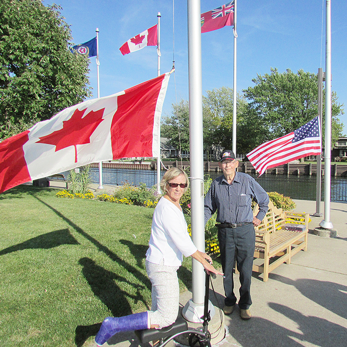 Yvonne Pinsonneault, with the help of Rex Crawford, filled two empty flag poles at Mitchell’s Bay Wharf recently, following a flap with the municipality over the safety of the poles.