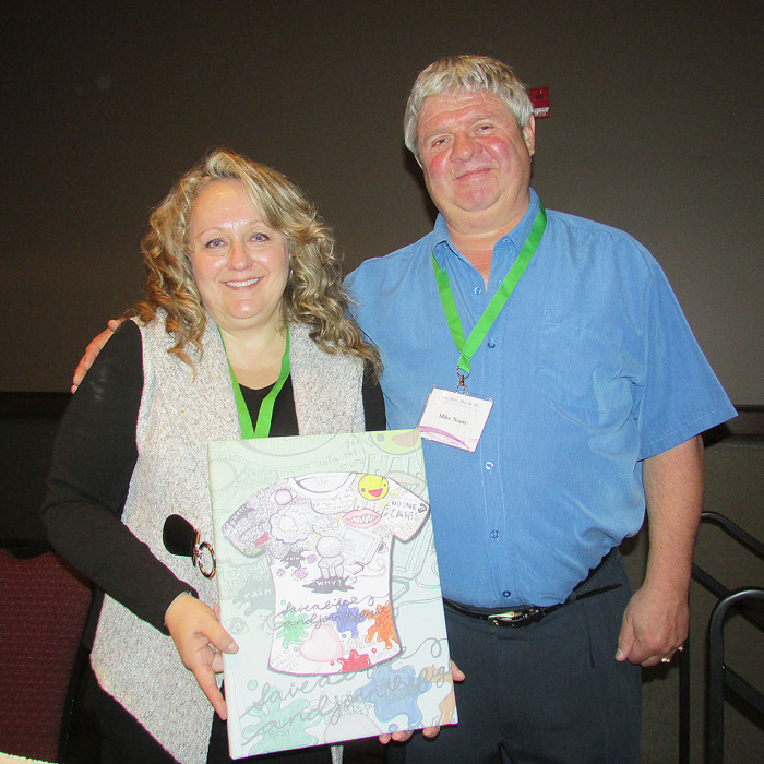 Dr. Leena Augimeri receives a painting from Mike Neuts, whose Make Children Better Now organization sponsored the recent children's mental health summit in Chatham.
