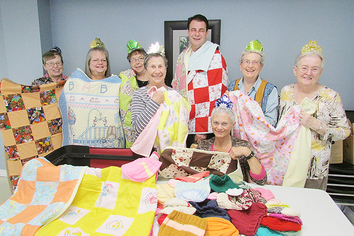 Showcasing some of the work done over the past year for the Chatham Goodfellows, the Stitchin’ Sisters wrap Goodfellow Tim Haskell in their quilts. From left is Diane Haskell, Joanne Smith, Mary Deturck, Stella Gleason, Haskell in back, Marlene Ternoey (sitting), Jane Jenner and Marlene Warren. 