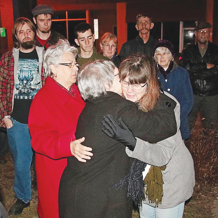 Valerie Carder, right, mother of John Robert Gallagher, a former Wheatley resident who was killed Nov. 4 in Syria while fighting alongside Kurdish forces against ISIS, is comforted after being presented with a prayer shawl made by Wheatley United Church members during a memorial service at Ivan Coulter Park Sunday.