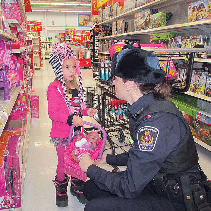 Chatham-Kent police Const. Jenna Jacobson and little Emma Dawson look for the perfect gifts for Emma and her family as part of Shop With a Cop at WalMart on Saturday.