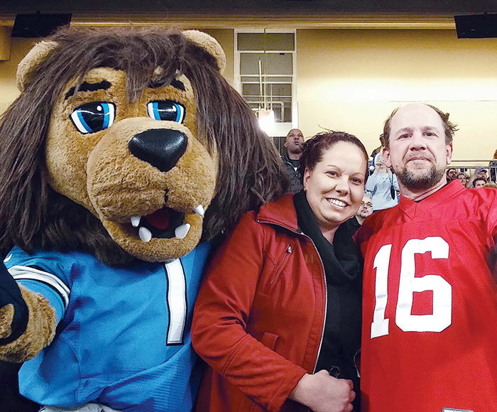 Roary, the Detroit Lions mascot, helped Chatham’s Dennis Parker, right, propose to his longtime girlfriend Davalyn Craven at a recent Lions home game. (Contributed image)