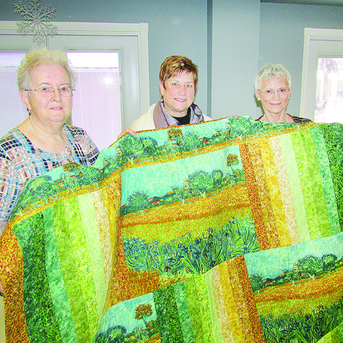 Marlene Warren, left, and Marlene Ternoey, right, present Michelle O’Rourke, director of services for the Chatham-Kent Hospice, with an honour quilt. Such a quilt is laid over a person who has passed away and is making his or her final journey to the front door of the hospice, accompanied by family, staff and volunteers.