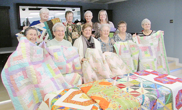 Members of the Stitchin’ Sisters donate 10 quilts to the Chatham-Kent Hospice. Front row, from left, Stella Gleason, Jane Jenner, Michelle O’Rourke (director of Hospice services), Marlene Warren, Mary Deturck and Barb Slavik. Back row, Barb Chandler, Diane Tatchell, Marlene Ternoey and Joanne Smith. There are 10 suites at the hospice, and now each will have its own unique quilt.