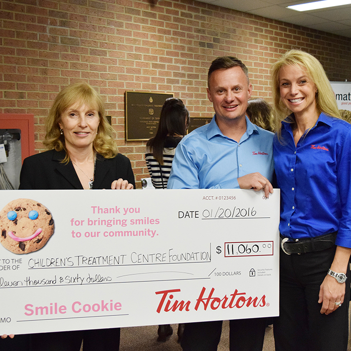 Donna Litwin-Makey, executive director of the Children’s Treatment Centre of Chatham-Kent, accepts a cheque for more than $11,000 from local Tim Hortons owners Mike and Paula Grail. The Grails teamed up with fellow Tim Hortons owner Guy Pritchard to run the Smile Cookie Program last fall, where all proceeds went to the treatment centre.
