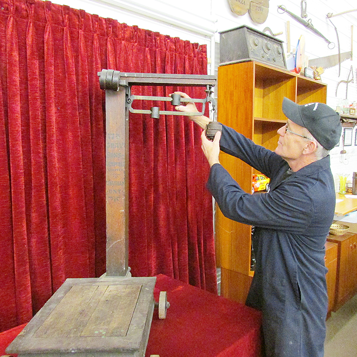 John Benedict of Maple City Auction Services stands next to a scale made by the William Gray plant shortly before it switched to automobile manufacturing in 1915.