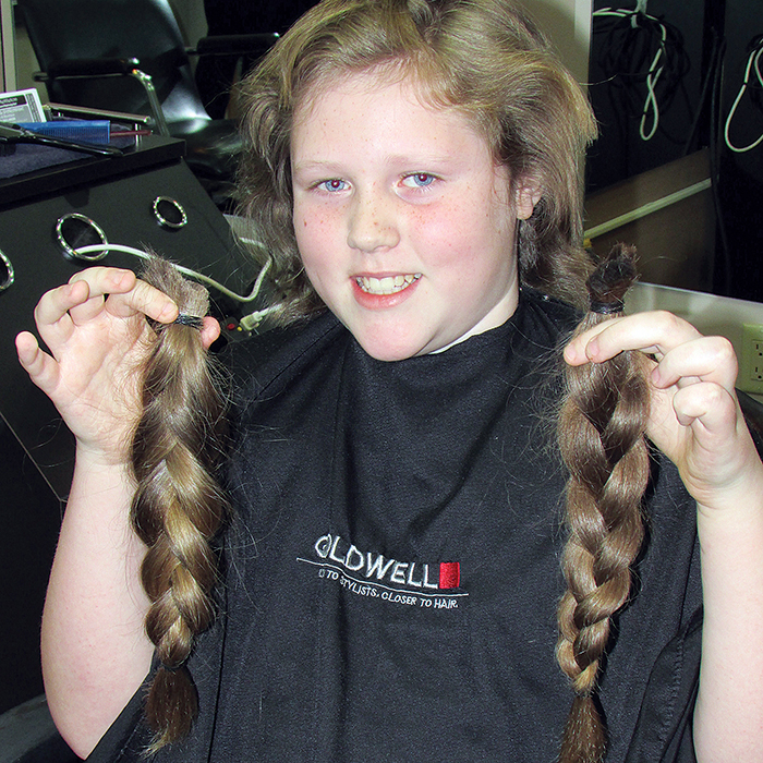 With a big grin in place, Johnathan Core holds up the end result of a year and a half of growing his hair out to donate to Locks of Love for wigs for cancer patients. Live on the TVO Kids’ segment, The Space, Core had 12 inches of hair cut at Tropical Paradise.