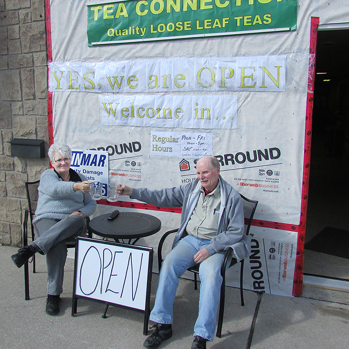 Julie and Alan McIntyre sit outside their storefront on King Street. The Tea Connection building was hit by a car at the end of February but the business has remained open.