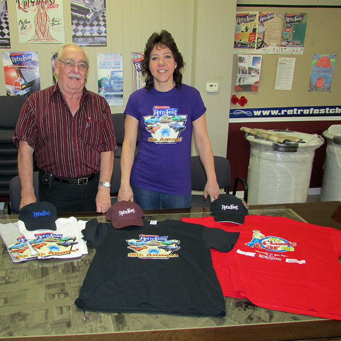 Len Langois of the Kent Historic Auto Club and Connie Beneteau of the Historic Downtown Chatham BIA show off some of the commemorative merchandise being sold to support this year’s Retrofest.