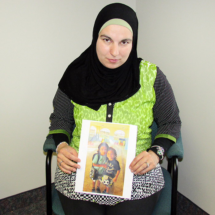 Jolly Bimbachi with a photo of her two boys Omar and A.G. She hasn’t seen her children since her husband took them to Lebanon for a vacation and didn’t return.