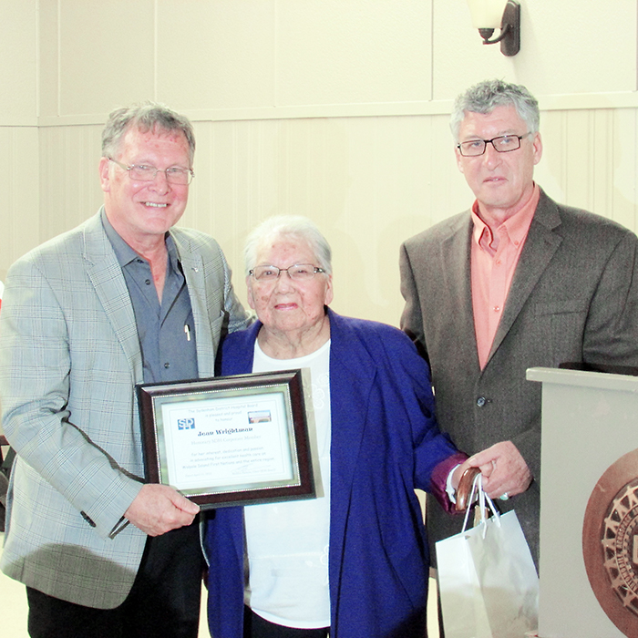 Sydenham District Hospital Corporation board members Sheldon Parsons (left) and Herb John present Jean Wrightman with an honourary membership to the corporation in recognition of her efforts in promoting local health care.