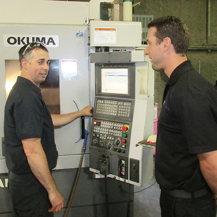 Leemark Enterprises employee Jeff Myers (left) shows Mike Parking one of the CNC machines which were part of an open house held last week at the Dresden area mould and die manufacturer.