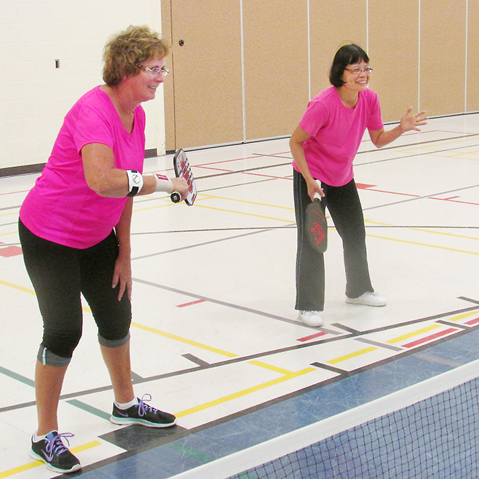 Peggy Hope, left, and Anne Leung were among more than 20 pickleball players taking part in a session at the WISH Centre recently. The sport is growing in popularity as snowbirds bring it back from Florida where is is a major activity.