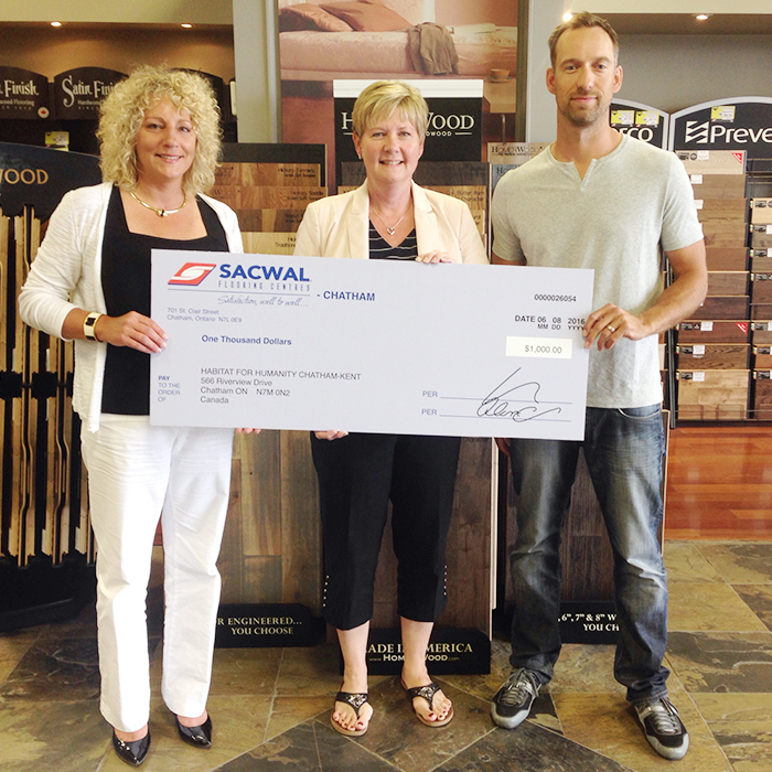 Alanna Aarssen from Sacwal Flooring is joined by Scott Vandersluis from Chatham-Kent Home Builders Association to present a cheque for $1000 to Nancy McDowell of Habitat for Humanity Chatham-Kent.