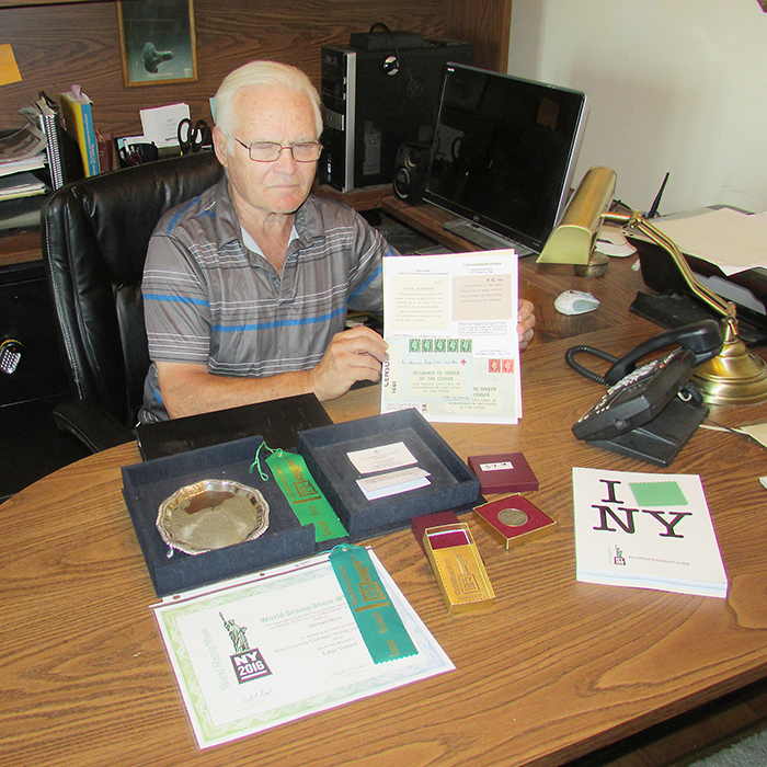Retired Wallaceburg area teacher Mike Deery won two major awards at last month’s New York World Stamp Show. He’s seen here with a sample page of his display and some of the awards.