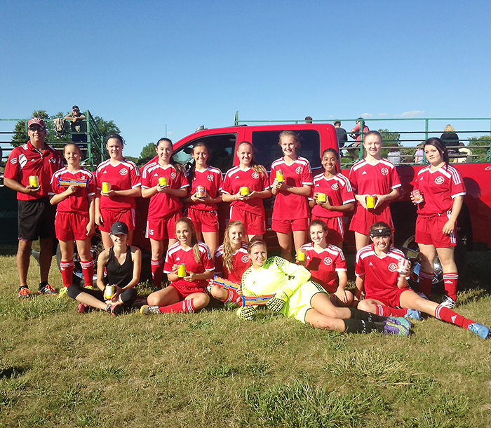 Members of the Chatham Strikers U17 girls’ soccer team and their coaches are filling the back of a Heuvelmans Chev pickup truck with non-perishable food items that will be donated to Outreach for Hunger.