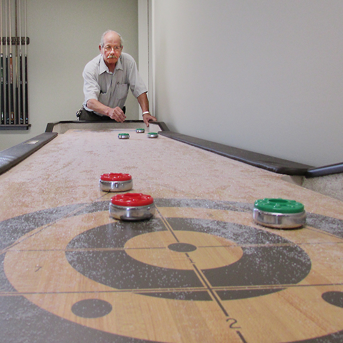 Ed Anson prepares to make a shot on the shuffleboard table at the new Blenheim and Community Senior Centre. The $1.1 million dollar facility on Jane Street will gradually open during the next few weeks.