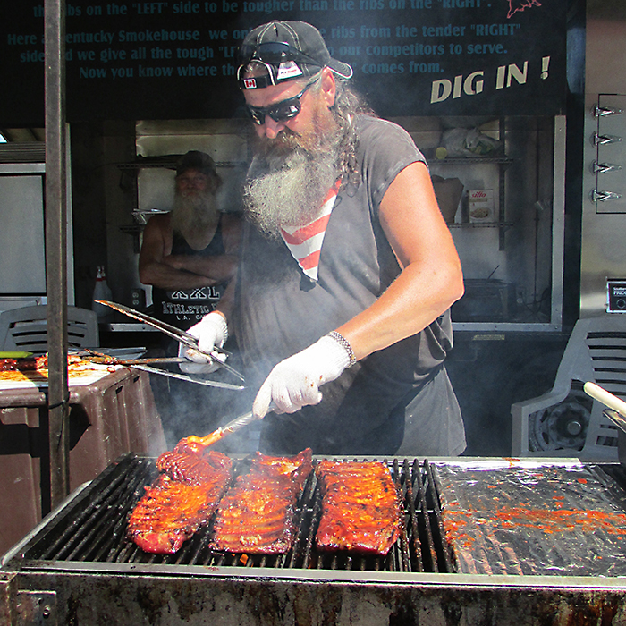 Tex Robert of the Kentucky Smokehouse rib team works the sauce into a rack of ribs on the grill during Chatham’s Rib Fest on the weekend.