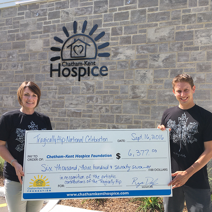Jodi Maroney of the Chatham-Kent Hospice receives her group’s share of the more than $17,000 raised through the screening of the Tragically Hip’s concert last month. Presenting the cheque is Ryan Doyle who organized the show in Tecumseh Park.