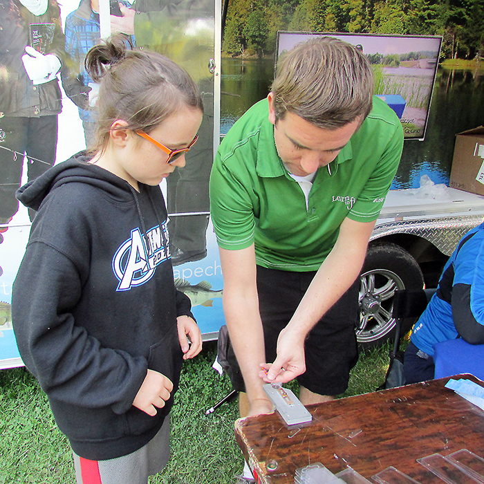 Grade 5 student Cameron Rand of Sarnia gets a helping hand from Jeff Brown of the Ministry of Natural Resources and Forestry in making a fishing lure during the annual Chatham-Kent and Lambton Water Festival. The event attracted record crowds of area students during its three day run.