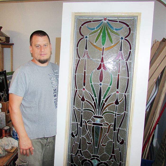 Jeff Cofell stands next to a door restoration project at the Magnolia Stained Glass Studio in Blenheim. He’s been crafting designs and doing restorations for several years.